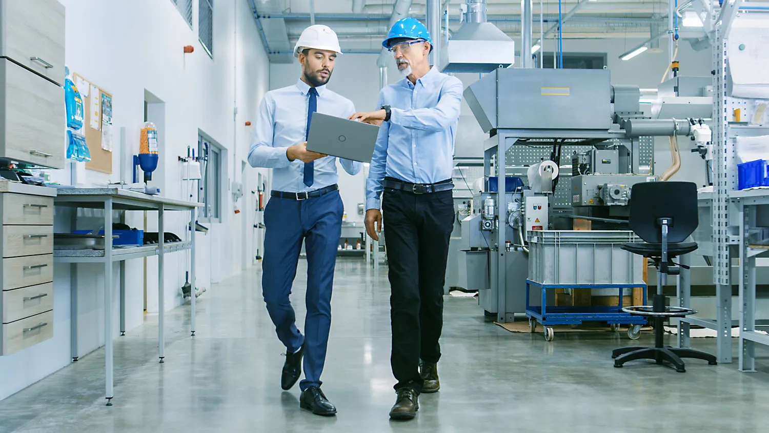 people in a factory talking about machinery